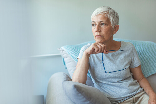 Senior woman on white sofa in white room