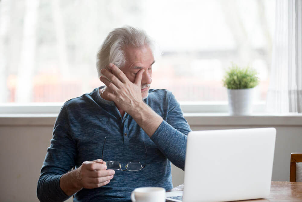 mature man rubbing his eye