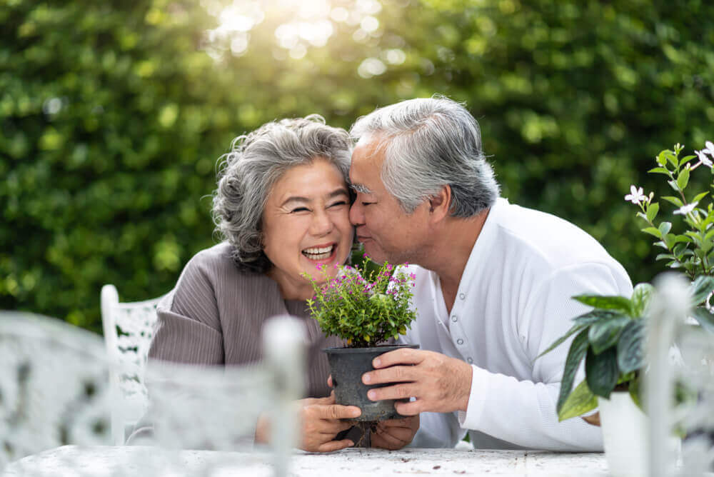 Mature couple at garden table, happy