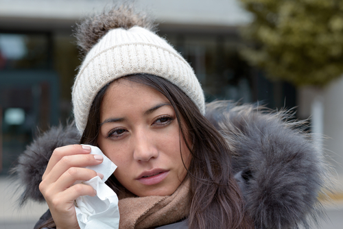 woman using tissue to wipe her eyes