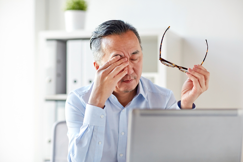 man rubbing his eye